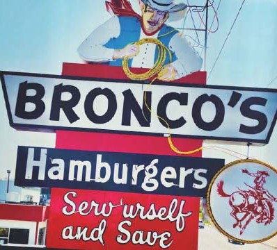 The historic Bronco's sign at 45th and Leavenworth: cowboy with lasso, Hamburgers, Serv'urself and Save